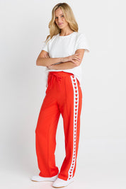 Model Genericm wearing size sample of the Jamie Track Pant – Tomato in colour Tomato, from the front