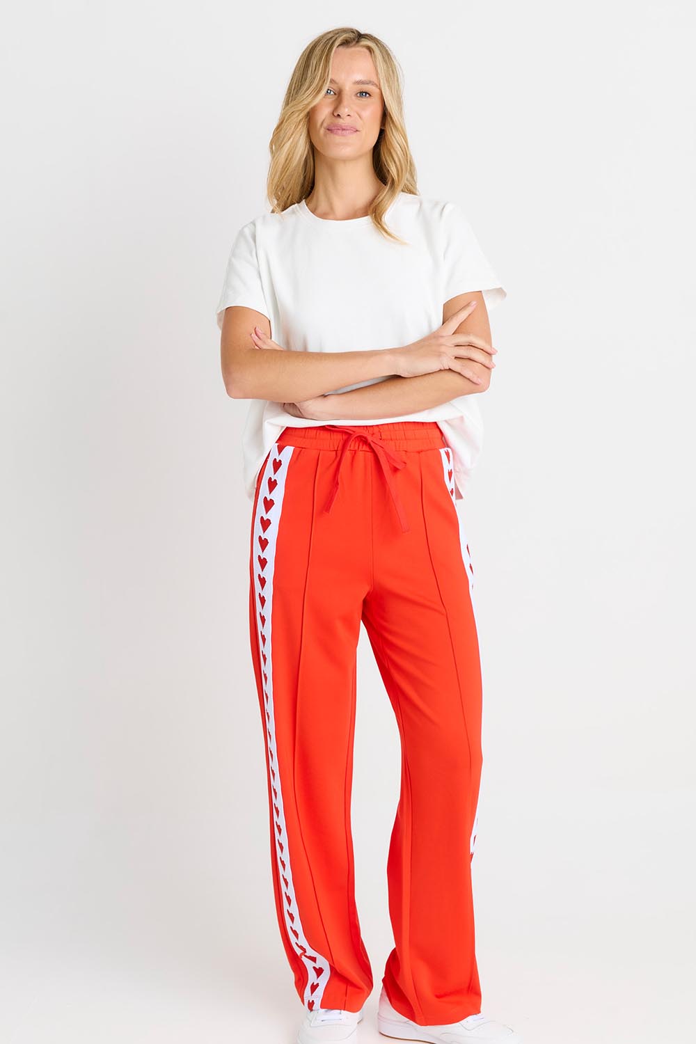 Model Genericm wearing size sample of the Jamie Track Pant – Tomato in colour Tomato, from the front