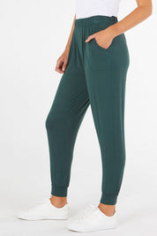 A model wearing the Paris Pant in colour Ivy (Green), from the front, cropped image