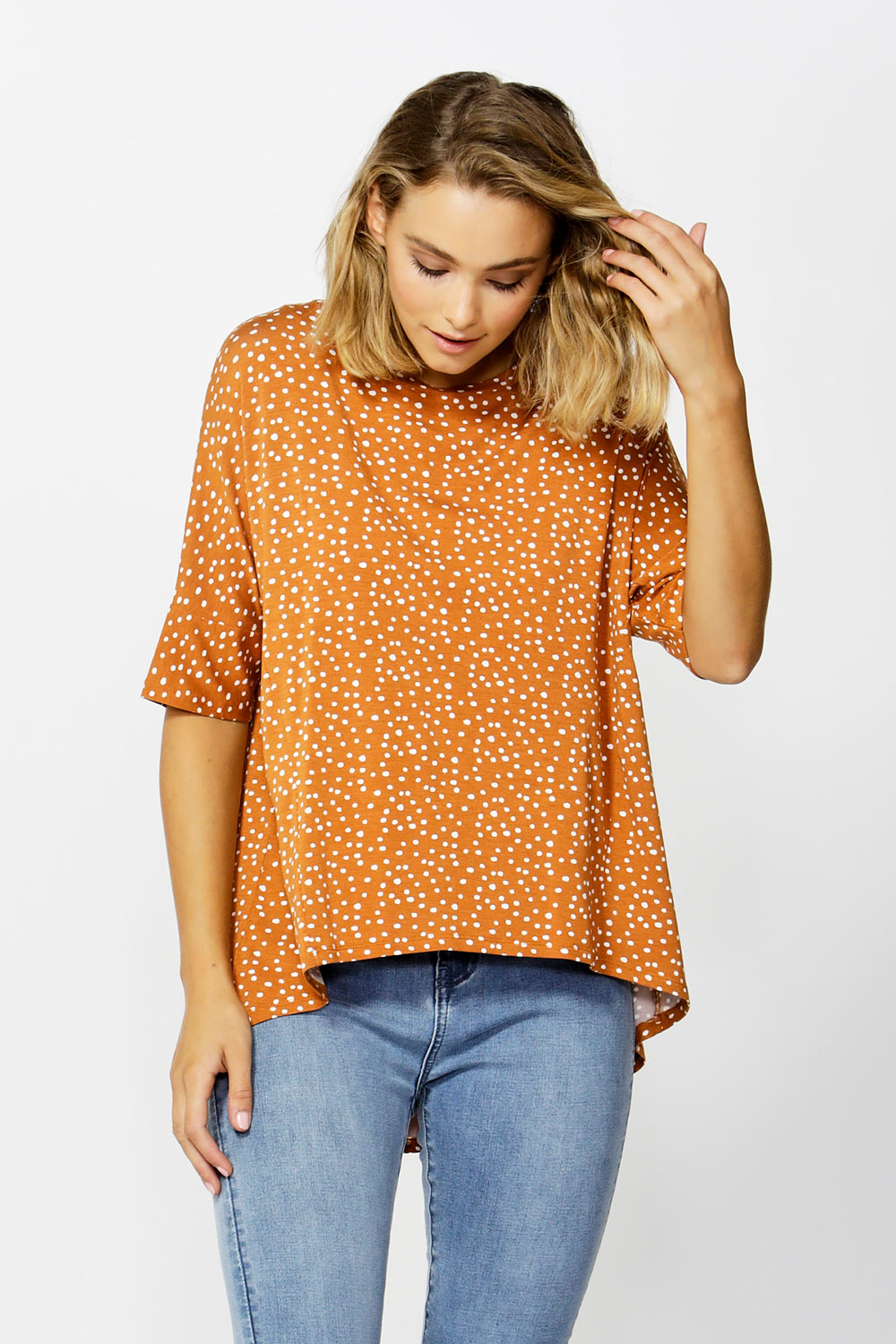A model wearing the Wellington Tee in colour ClaySpot, from the front, cropped image
