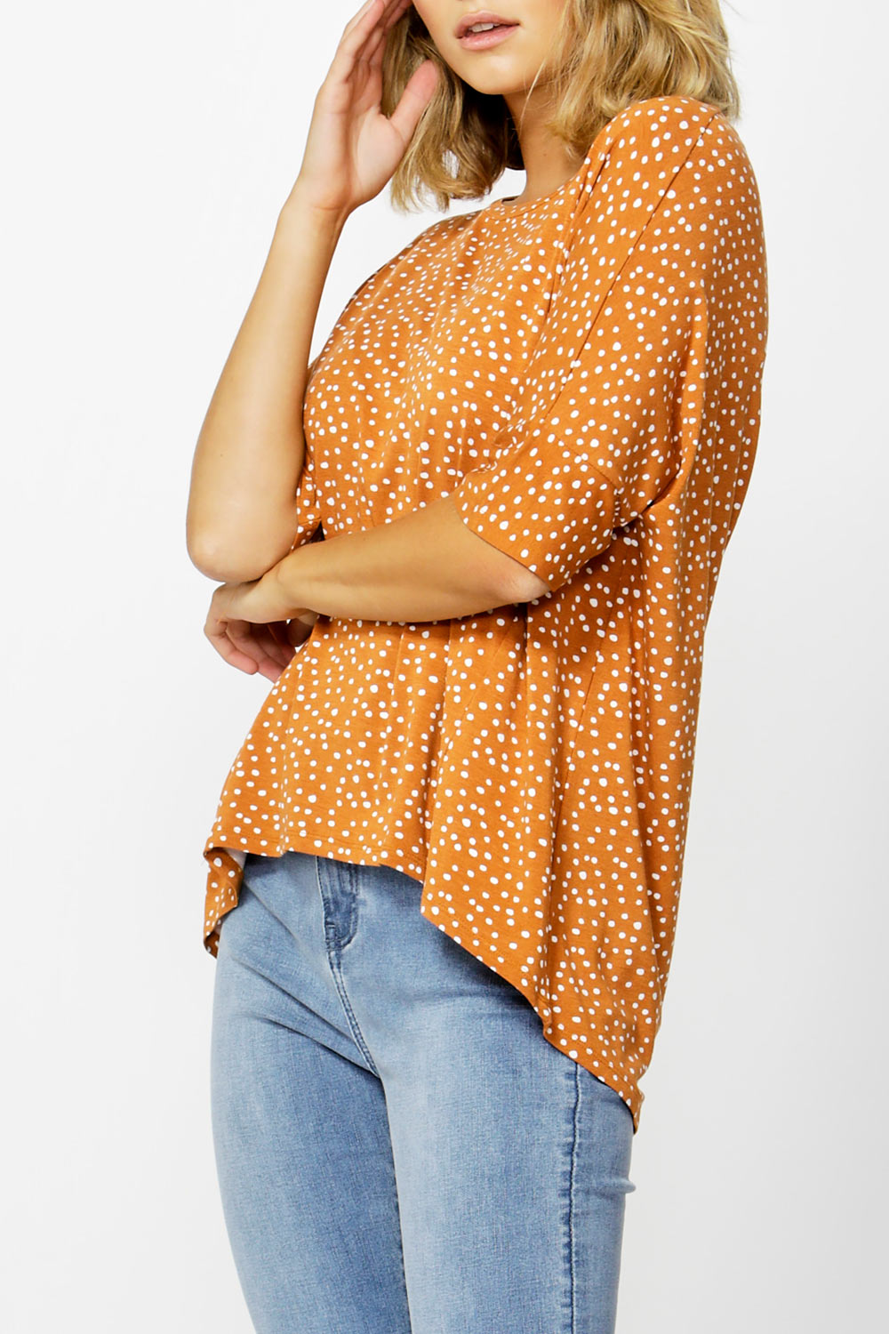 A model wearing the Wellington Tee in colour ClaySpot, from the front, cropped image