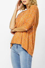 A model wearing the Wellington Tee in colour ClaySpot, from the front, cropped image