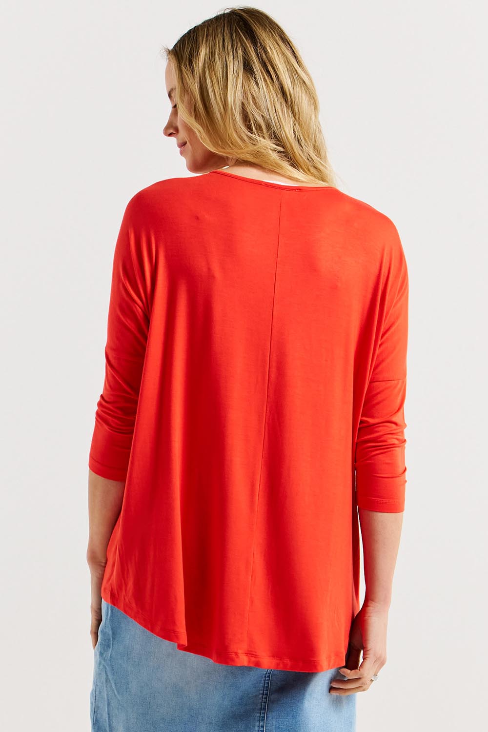 A model wearing the Milan 3/4 Sleeve Top in colour Flamered (Red), from the back