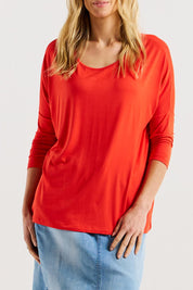 A model wearing the Milan 3/4 Sleeve Top in colour Flamered (Red), from the front, cropped image
