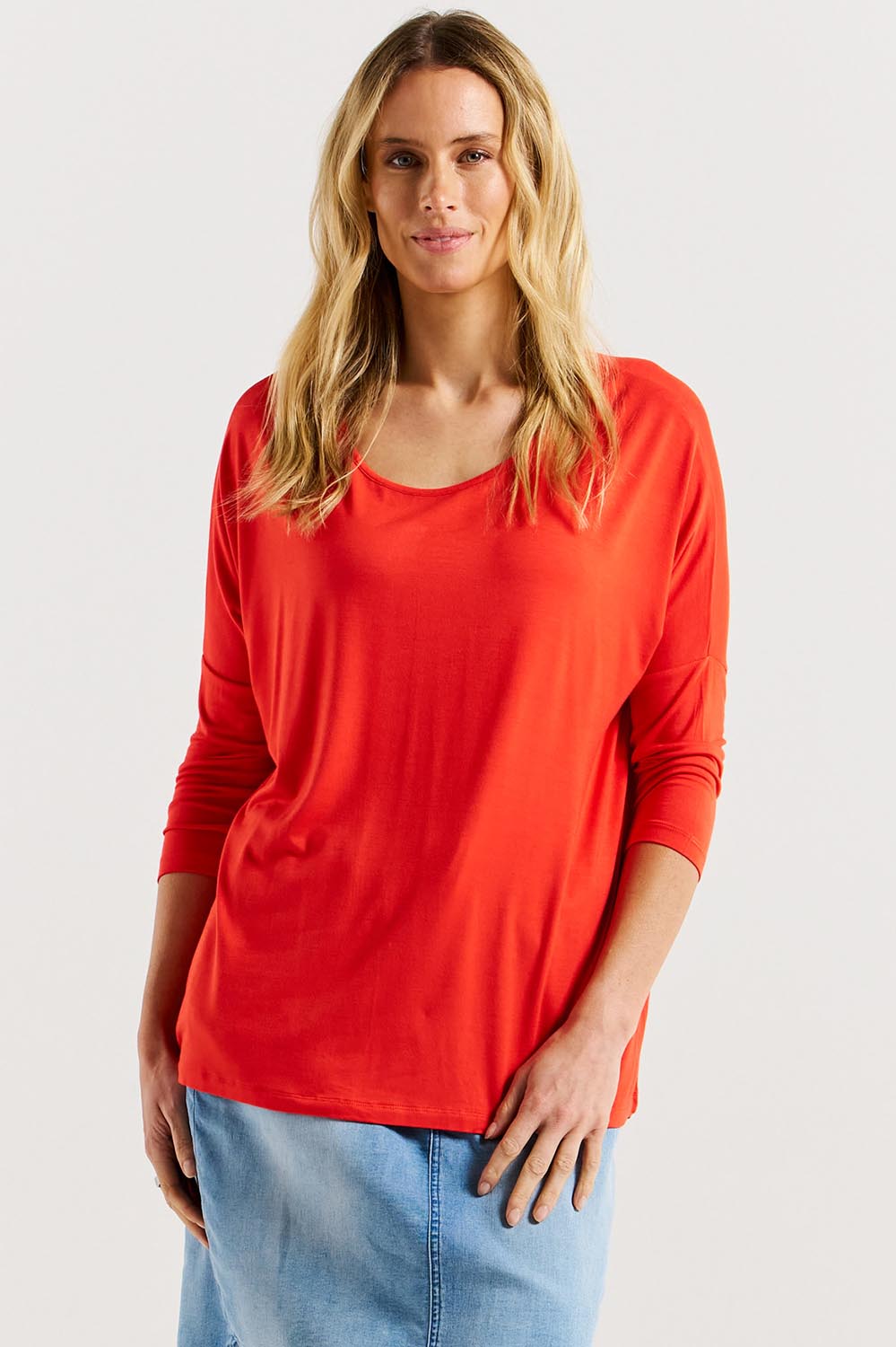 A model wearing the Milan 3/4 Sleeve Top in colour Flamered (Red), from the front, cropped image