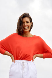 A model wearing the Milan 3/4 Sleeve Top in colour Flamered (Red), from the front, showing the whole outfit