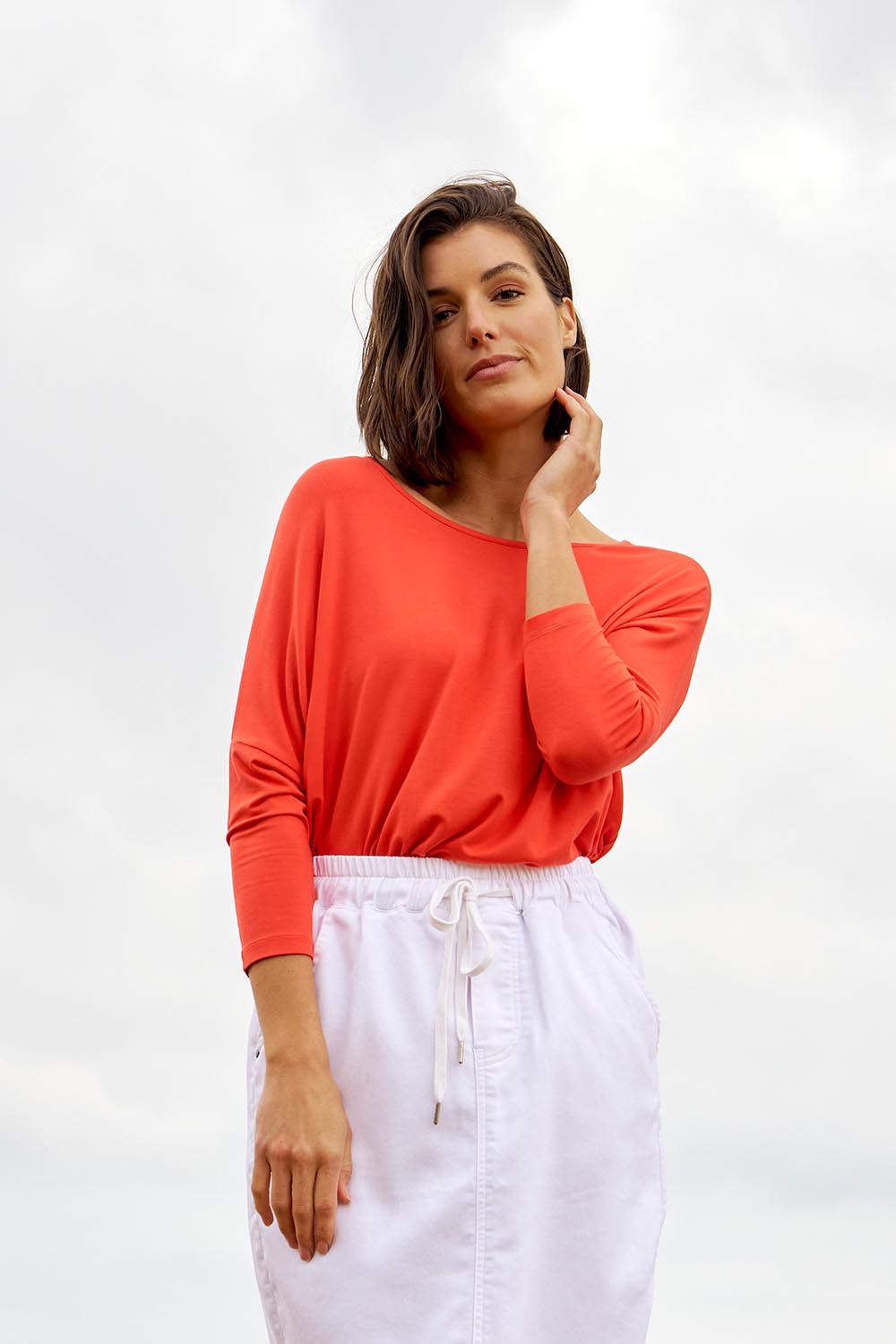 A model wearing the Milan 3/4 Sleeve Top in colour Flamered (Red), from the front, showing the whole outfit