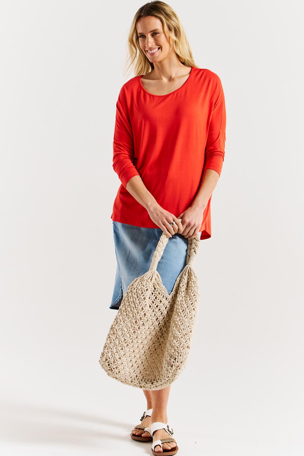 A model wearing the Milan 3/4 Sleeve Top in colour Flamered (Red), from the front, showing the whole outfit