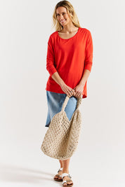 A model wearing the Milan 3/4 Sleeve Top in colour Flamered (Red), from the front, showing the whole outfit