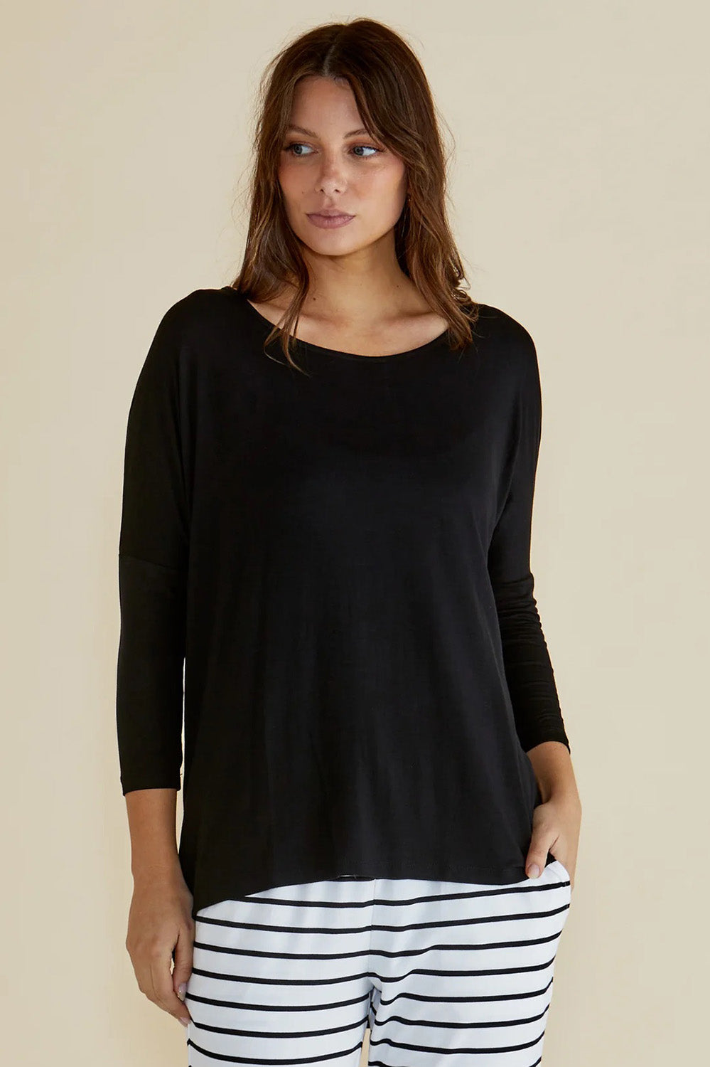 A model wearing the Milan Stretch Top in colour Black (Black), from the front, cropped image