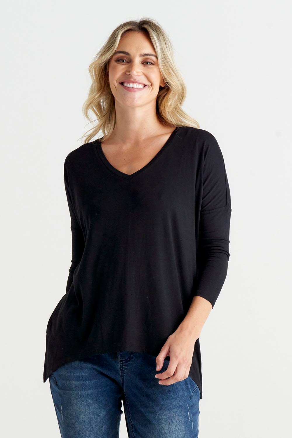A model wearing the Geneva Tee in colour Black (Black), from the front, cropped image