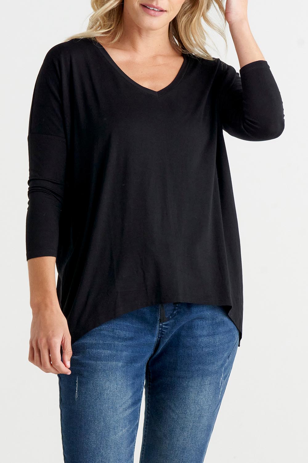 A model wearing the Geneva Tee in colour Black (Black), from the front, cropped image