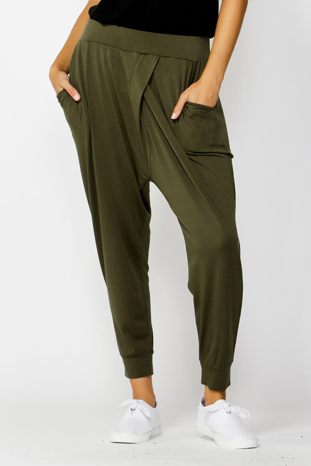 A model wearing the Darwin Pant in colour Olive (Green), from the front, cropped image