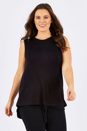 Model Tia wearing size 14 of the Capri Tank in colour Black (Black), from the front, cropped image