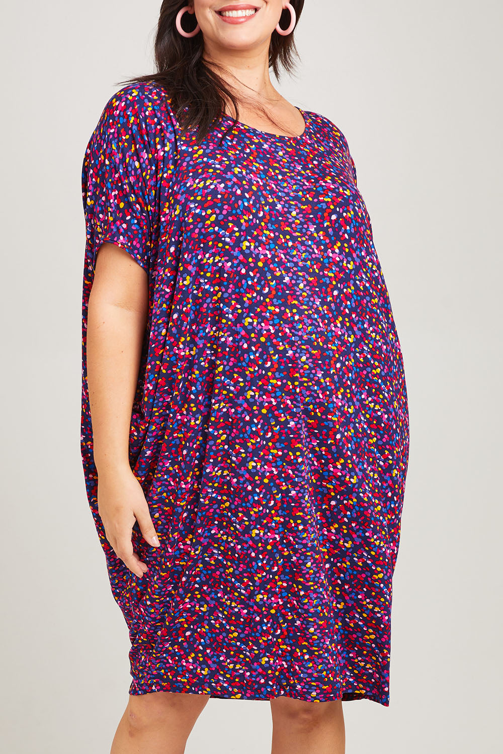 Model Poppy wearing size 16 of the Maui Dress in colour Confetti (Blue), from the front, cropped image