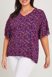 Model Caitlin wearing size 16 of the Ripon Top in colour Confetti (Blue), from the front, cropped image