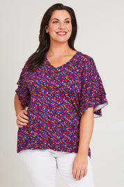 Model Poppy wearing size 16 of the Ripon Top in colour Confetti (Blue), from the front, cropped image
