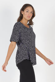 Model Madeline wearing size 10 of the Sicily Top in colour Geo (Black), from the front, cropped image