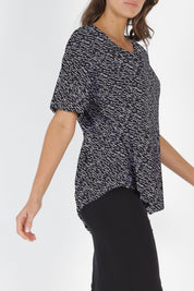 Model Madeline wearing size 10 of the Sicily Top in colour Geo (Black), from the front, cropped image