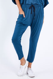 Model Vitoria wearing size 10 of the Hamilton Pant in colour Teal (Green), from the front, cropped image
