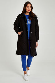 Model Madeline wearing size 10 of the Tribeca Puffer Jacket in colour Black (Black), from the front, showing the whole outfit