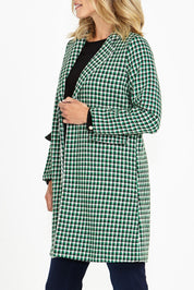 A model wearing the Wanda Coat in colour Greenhound (Green), from the front, cropped image