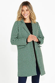 A model wearing the Wanda Coat in colour Greenhound (Green), from the front, cropped image