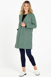 A model wearing the Wanda Coat in colour Greenhound (Green), from the front, showing the whole outfit