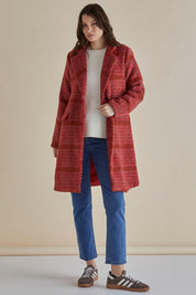 A model wearing the Wanda Coat in colour Rouge (Red), from the front, showing the whole outfit