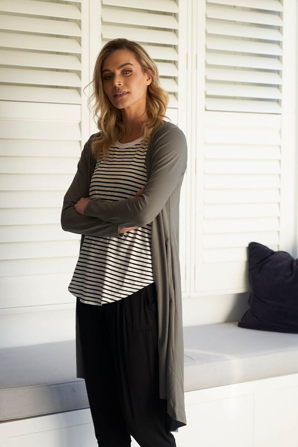 A model wearing the Byron Cardigan in colour Ashgreen, from the front, showing the whole outfit