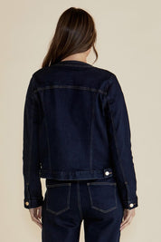 A model wearing the Cindy Collarless Denim Jacket in colour Ink (Blue), from the back