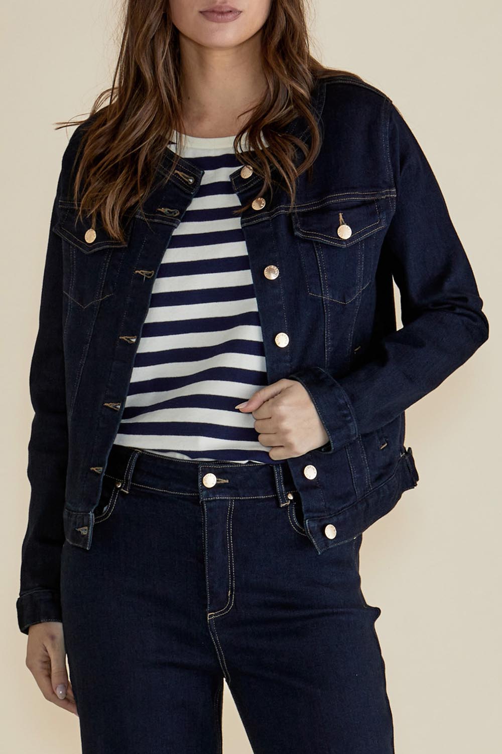 A model wearing the Cindy Collarless Denim Jacket in colour Ink (Blue), from the front, cropped image