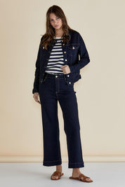A model wearing the Cindy Collarless Denim Jacket in colour Ink (Blue), from the front, showing the whole outfit