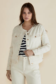 A model wearing the Cindy Collarless Denim Jacket in colour Offwhite (White), from the front, cropped image