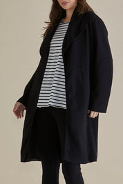 A model wearing the Gabriel Coat in colour Black (Black), from the front, cropped image