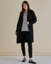 A model wearing the Gabriel Coat in colour Black (Black), from the front, showing the whole outfit