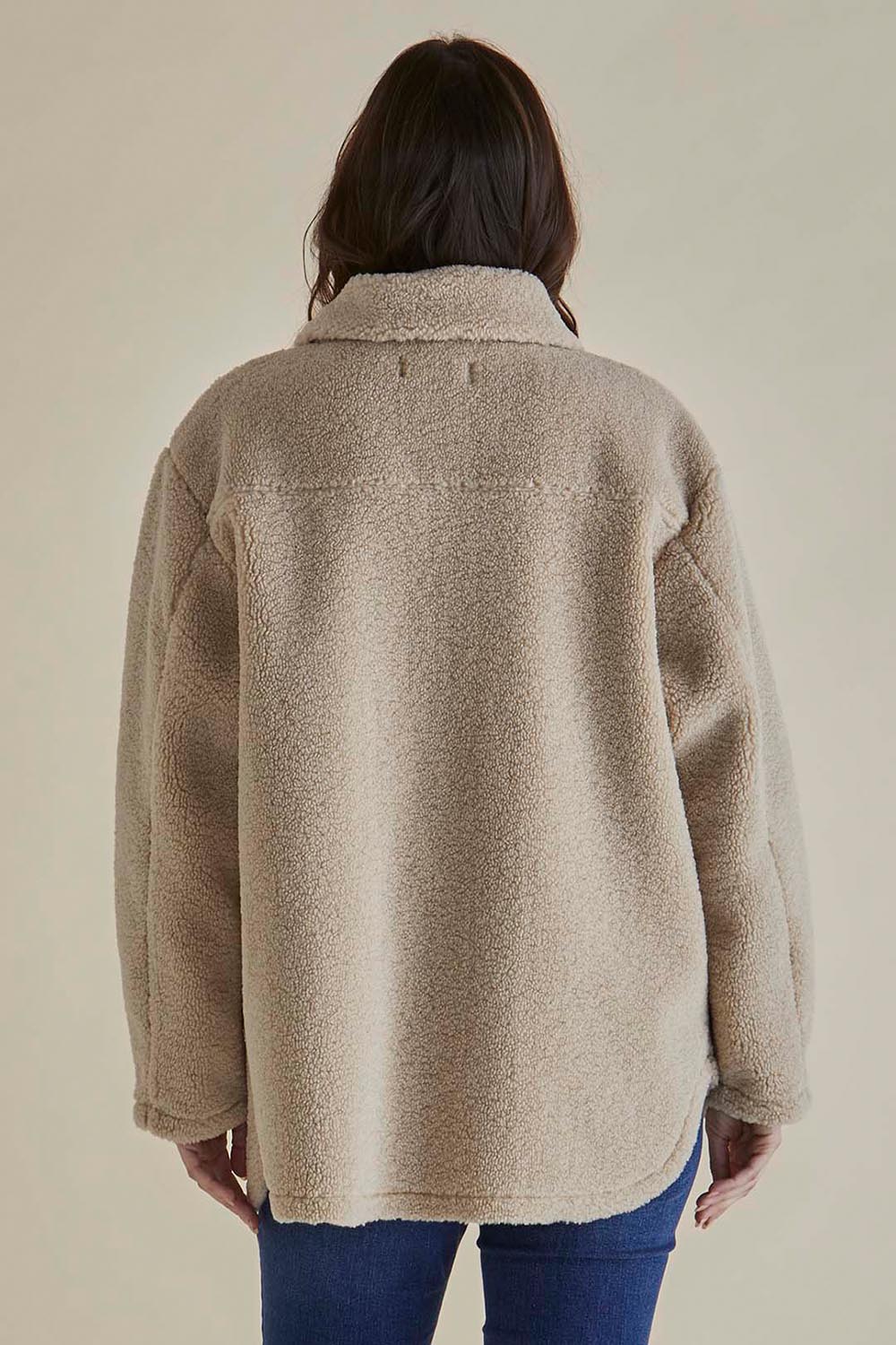 A model wearing the Teddy Jacket in colour Latte, from the back