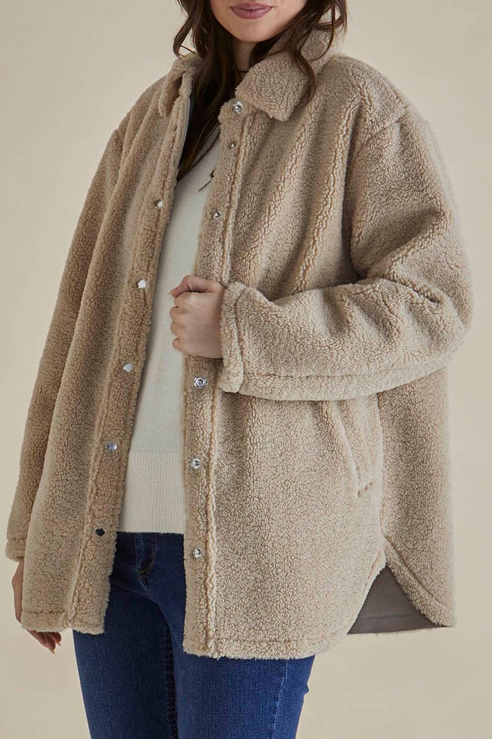 A model wearing the Teddy Jacket in colour Latte, from the front, cropped image