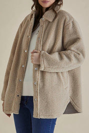 A model wearing the Teddy Jacket in colour Latte, from the front, cropped image