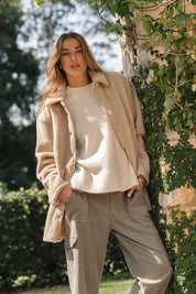 A model wearing the Teddy Jacket in colour Latte, from the front, showing the whole outfit