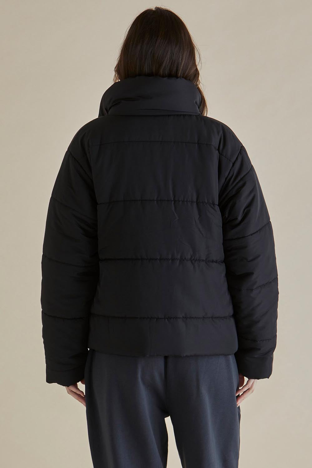 A model wearing the Presley Puffer Jacket in colour Black (Black), from the back