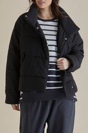 A model wearing the Presley Puffer Jacket in colour Black (Black), from the front, cropped image
