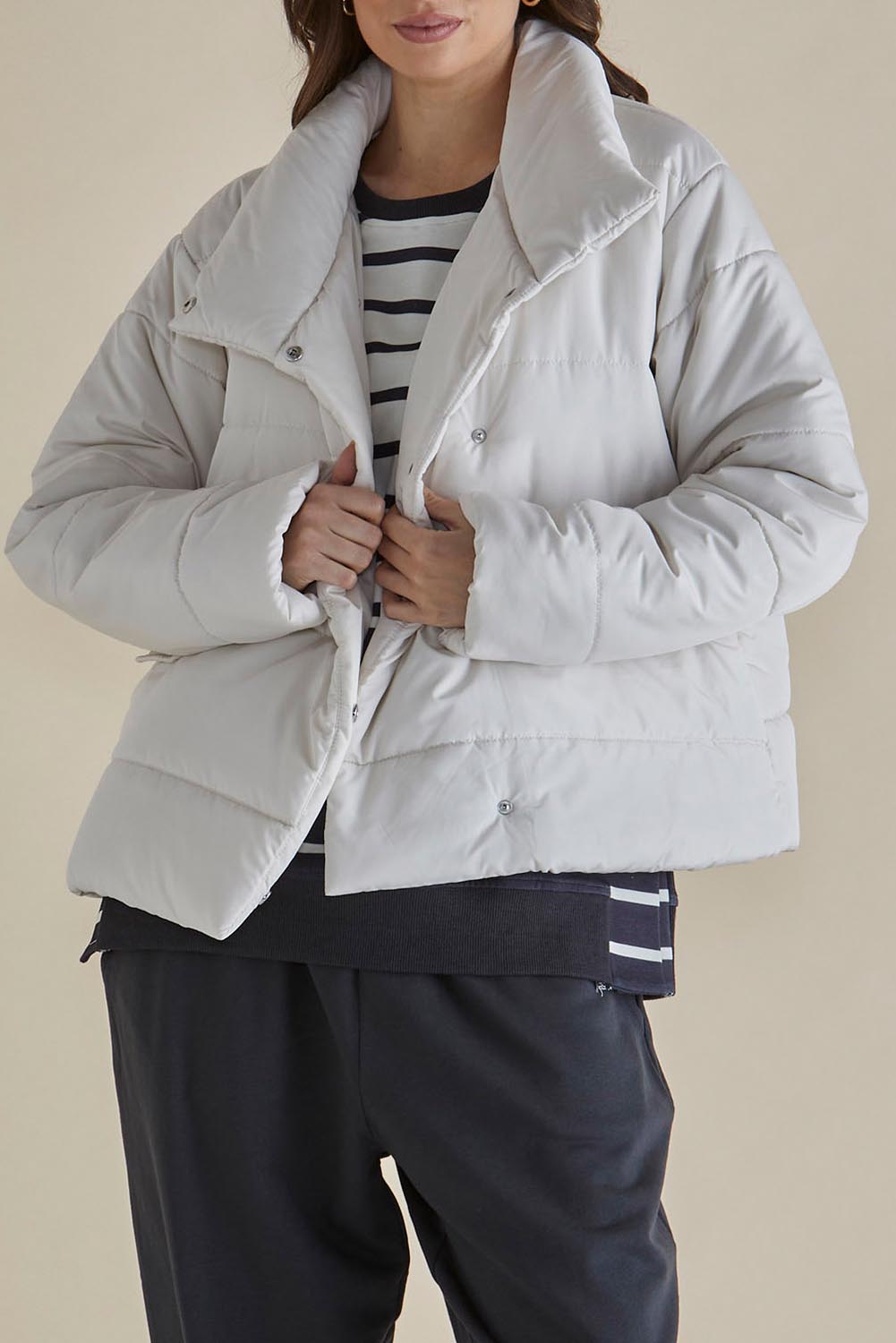 A model wearing the Presley Puffer Jacket in colour Pearl, from the front, cropped image