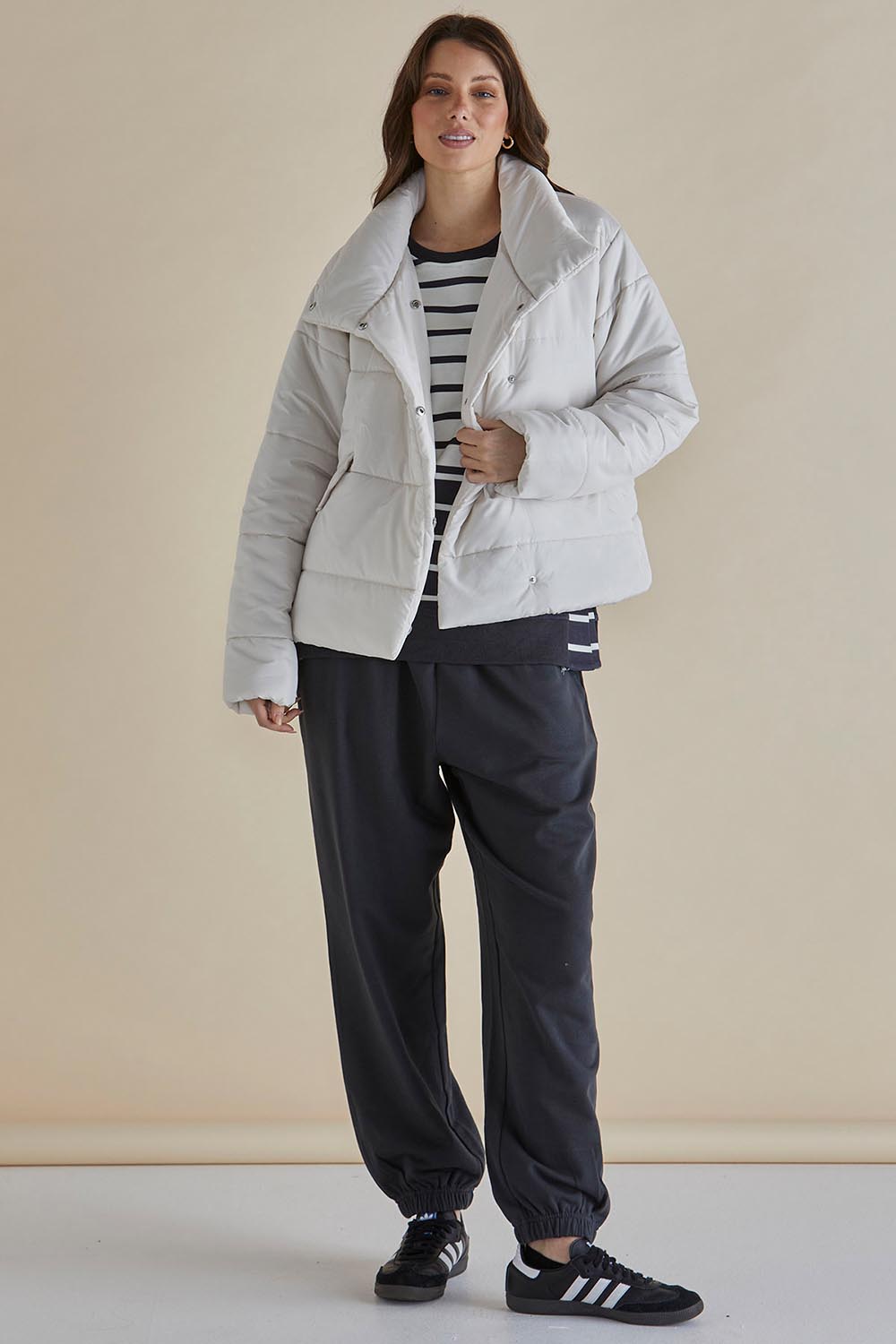 A model wearing the Presley Puffer Jacket in colour Pearl, from the front, showing the whole outfit