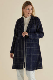 A model wearing the Genevieve Coat in colour Navycheck (Blue), from the front, cropped image