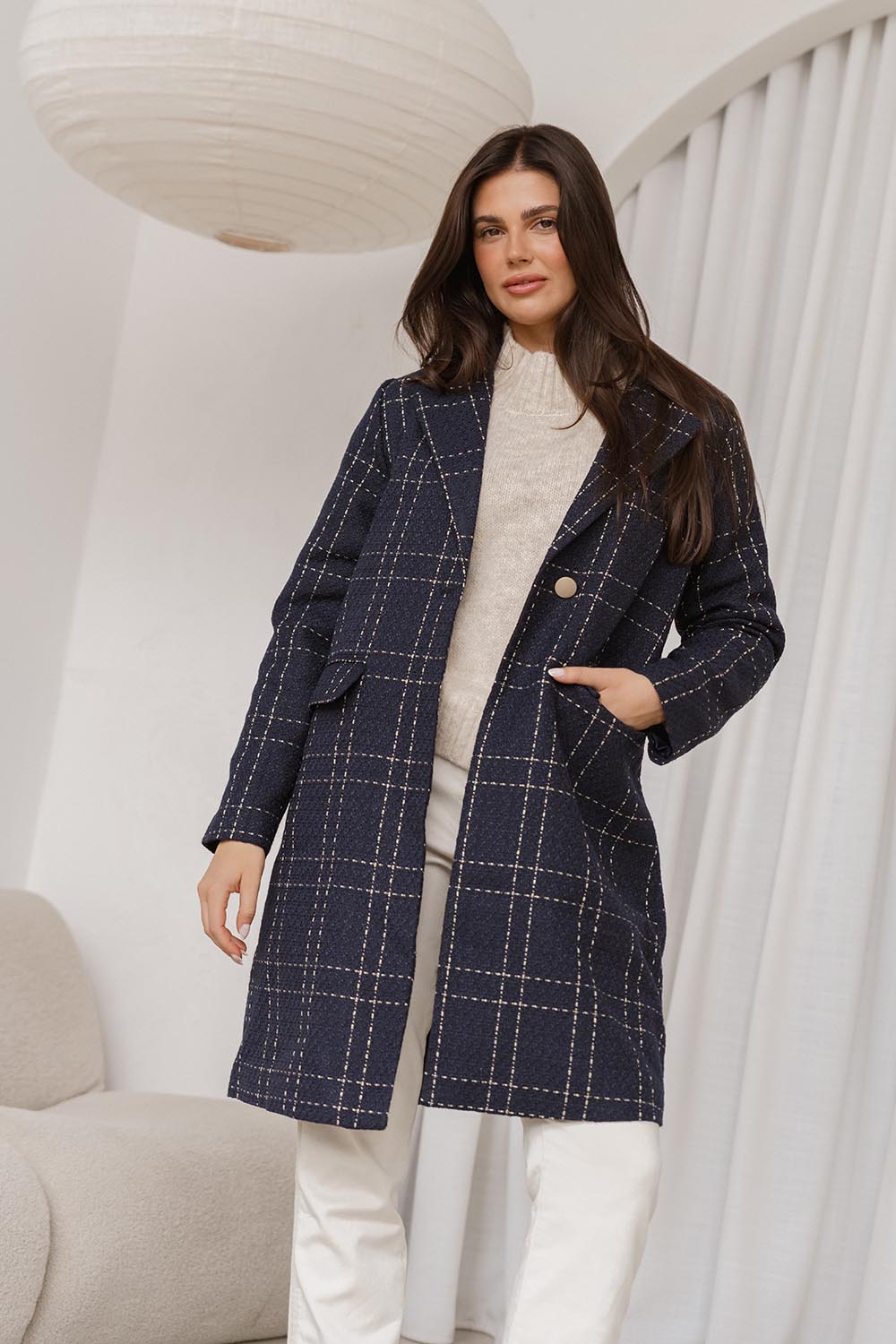 A model wearing the Genevieve Coat in colour Navycheck (Blue), from the front, showing the whole outfit