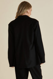 A model wearing the Portland Blazer in colour Black (Black), from the back