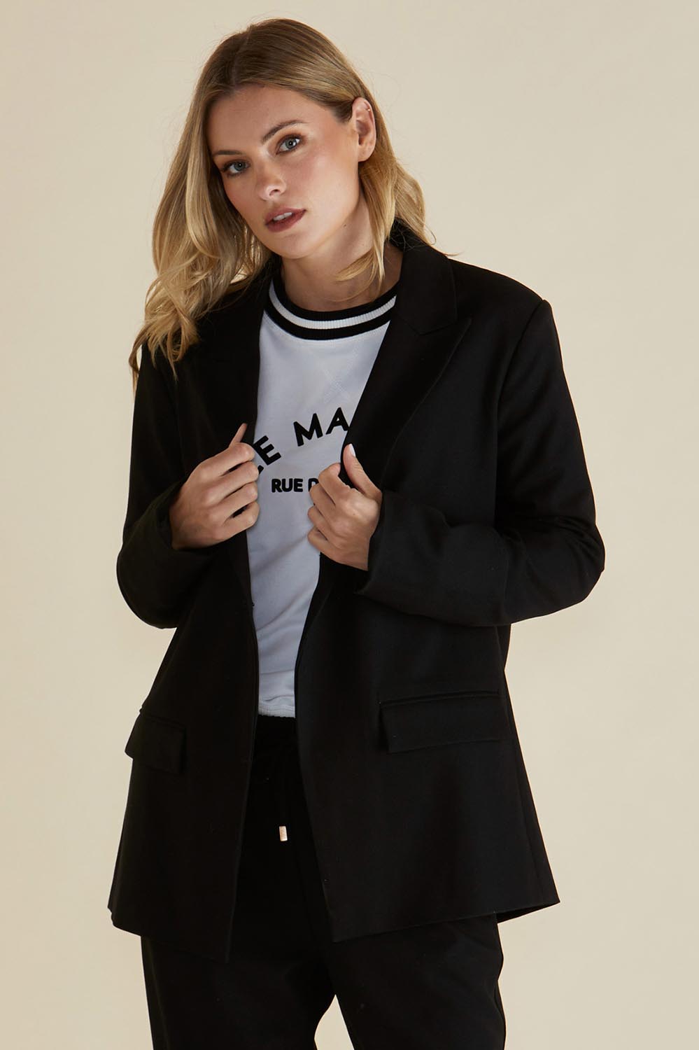 A model wearing the Portland Blazer in colour Black (Black), from the front, cropped image
