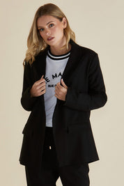 A model wearing the Portland Blazer in colour Black (Black), from the front, cropped image
