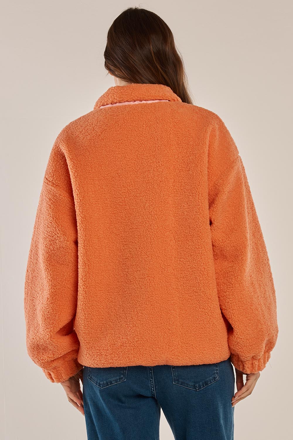 A model wearing the Jayne Fleece Jacket in colour Pinkorange (Pink), from the back